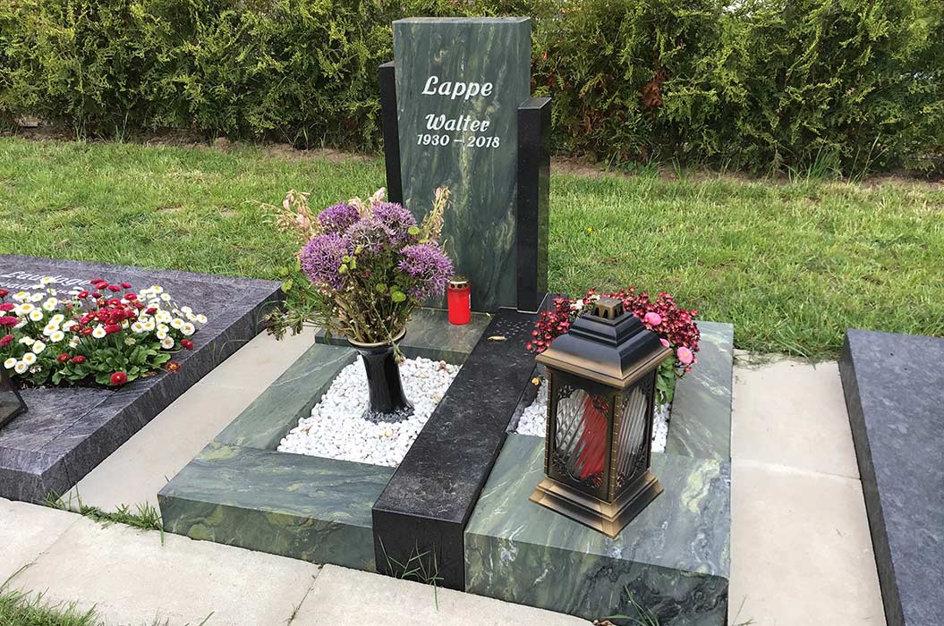 Grabstein mit Blumenarrangement und Laterne, grüner Rahmen, Inschrift "Lappe Walter 1930–2018".