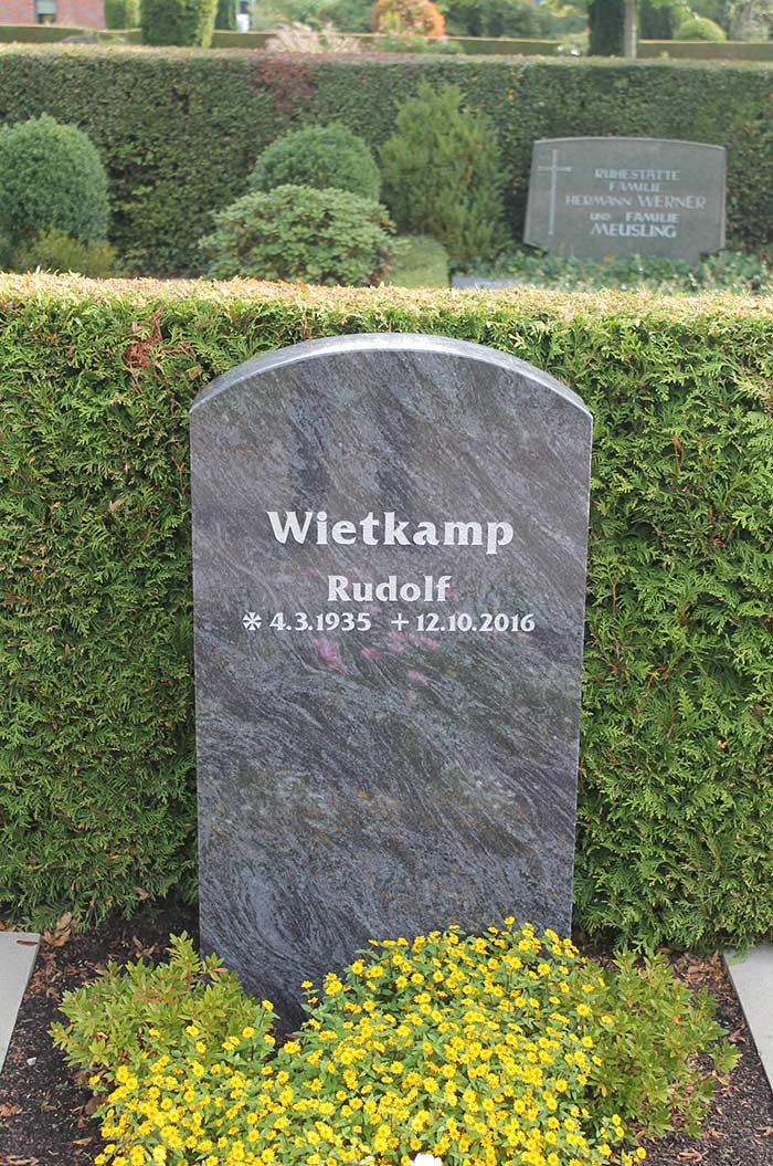 Grabstein eines Verstorbenen namens Rudolf Wietkamp auf einem friedlichen Friedhofsumfeld.