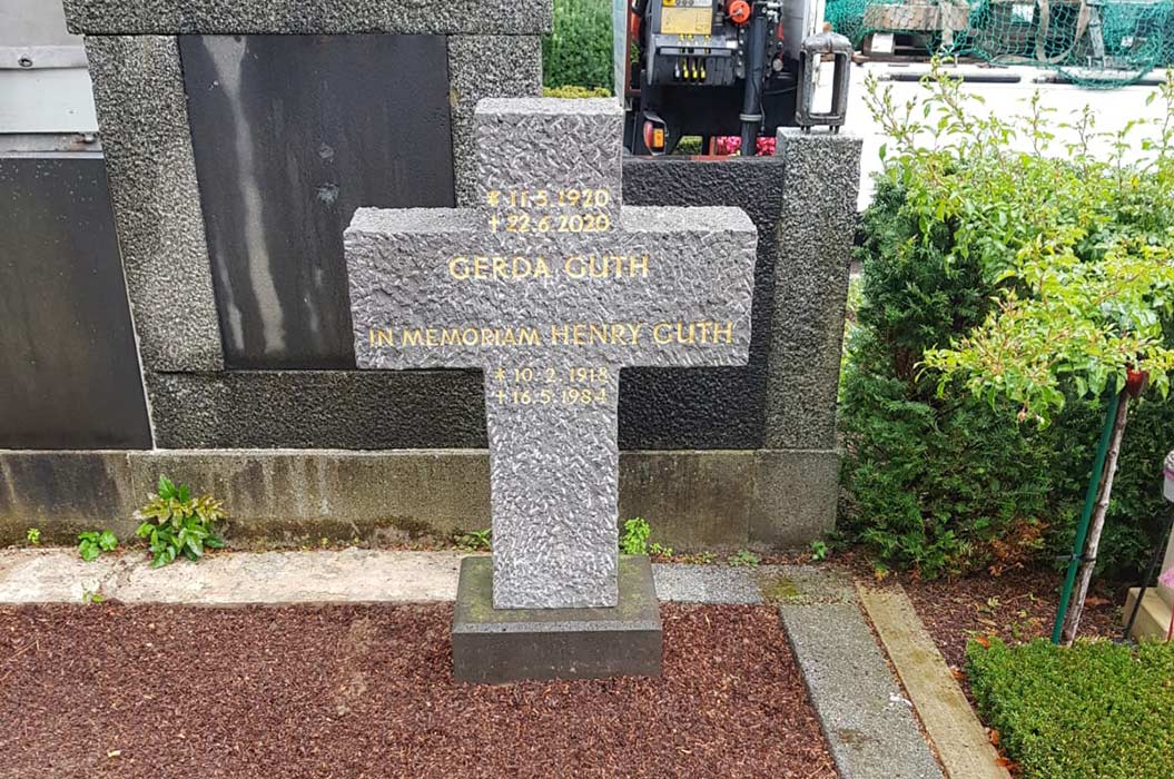Steingrab mit Inschrift, Pflanzen im Hintergrund, Gedenkstätte für Gerda und Henry Guth.