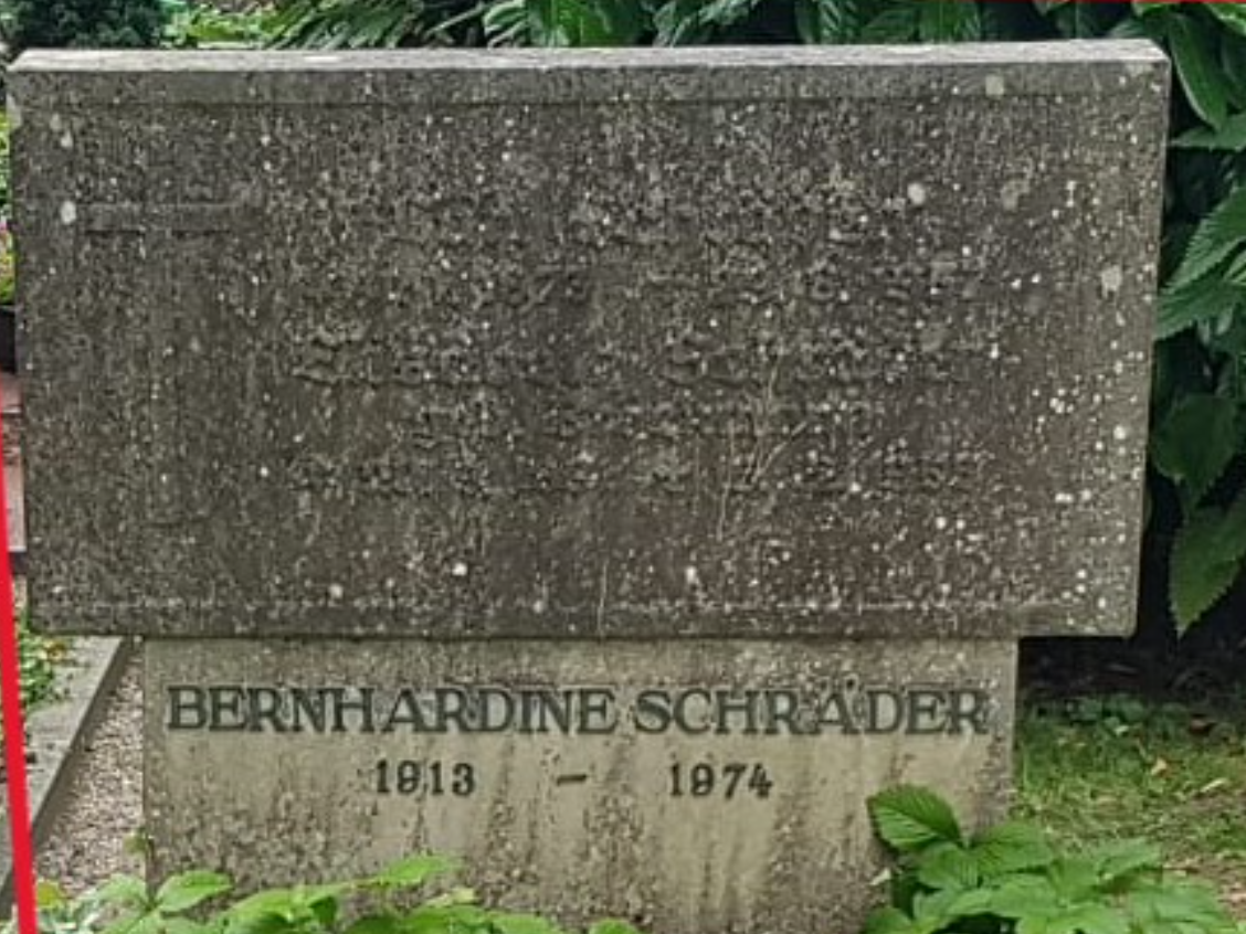 Ein moosbedeckter Grabstein mit der Inschrift Bernhardine Schrader 1813 1874